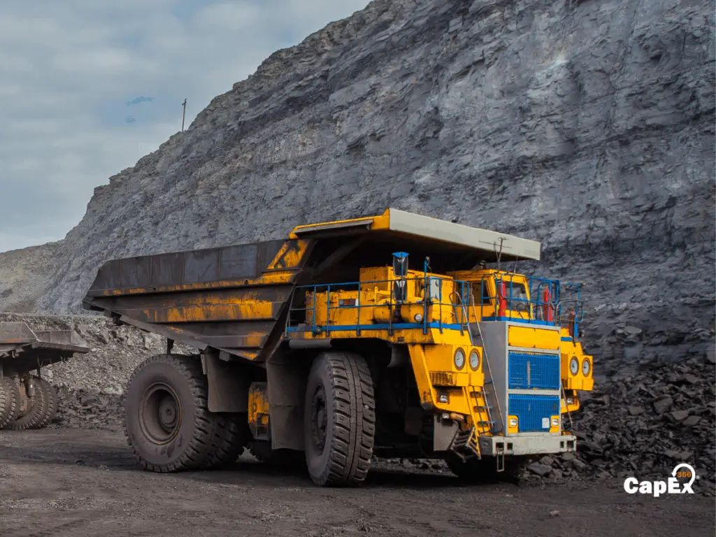 Mining site with heavy equipment and haul trucks used in capital-intensive operations